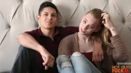 Verliebtes junges Paar mit blonder Teen auf weißer Steppwand sitzend, er im Polohemd, sie lächelnd im Cardigan