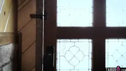 Arzt in weißem Kittel vor Holz-Glastür, Sonnenlicht fällt herein