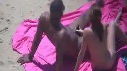 Paar auf pinker Decke beim Strandsex