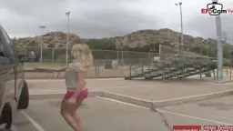 Blonde in pinkem Hotpants steigt sexy aus silbernem Van auf Parkplatz