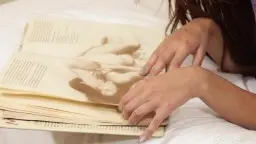 Kada Love liegt nackt auf weißem Bett und drückt sich einen großen Dildo tief in ihre nasse Muschi