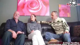 Brünette Friseuse im pinken BH kniet nackt auf dem Ledersofa und wird von drei Männern umringt